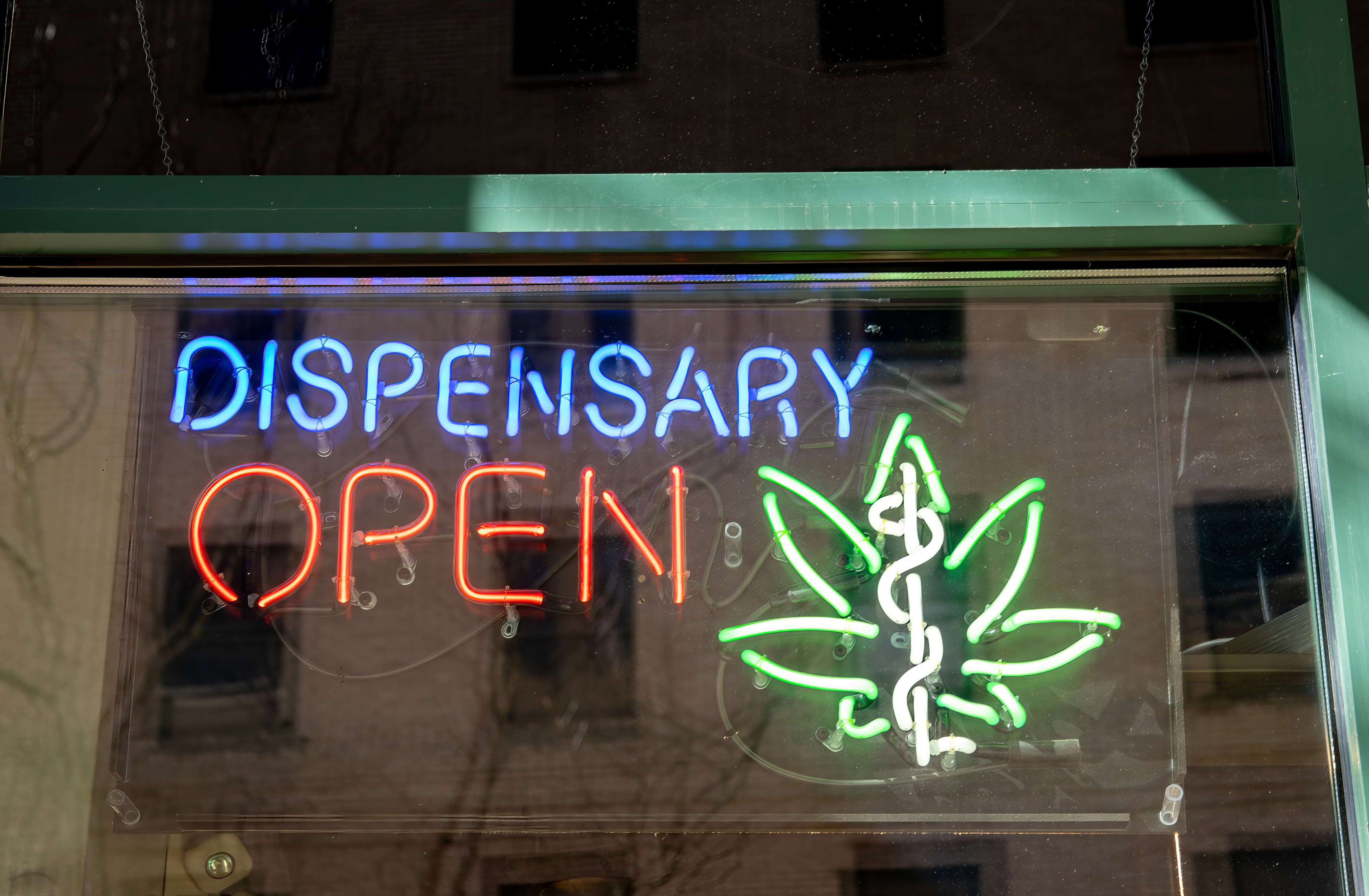 Neon sign advertising legal, medical marijuana dispensary in store window